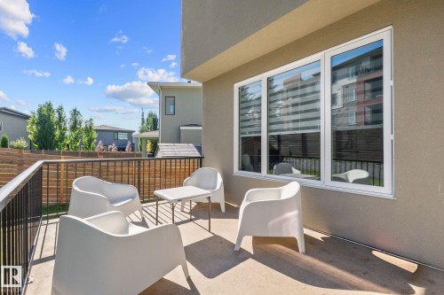 Exterior balcony featuring a concrete surface, black metal railings, and a horizontal wood privacy fence - 2019 Ware Rd Nw, Edmonton, AB 
