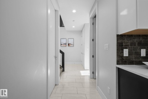 Hallway featuring light-toned tile flooring, recessed lighting, and white walls - 2019 Ware Rd Nw, Edmonton, AB 