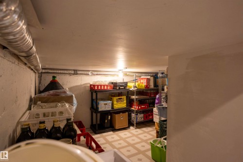 Basement storage area featuring tile flooring, exposed ductwork, and built-in shelving - 6407 163 Avenue Nw, Edmonton, AB 