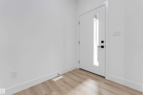 Entryway featuring a contemporary white door with a vertical pane of glass, matte black hardware, and light wood-finish flooring - 4234 63 Street, Beaumont, AB - Indoor Photo Showing Other Room