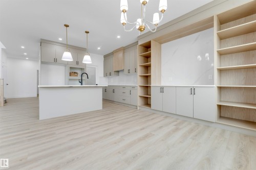 Open-concept living area featuring light wood-finish flooring, a contemporary chandelier, and recessed lighting - 4234 63 Street, Beaumont, AB - Indoor Photo Showing Kitchen