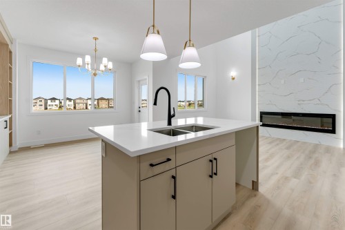 Kitchen island with a white countertop and double basin sink - 4234 63 Street, Beaumont, AB - Indoor Photo Showing Kitchen With Double Sink