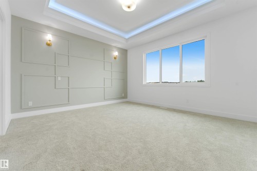 Spacious room featuring accent wall with decorative molding, recessed ceiling lighting, and twin wall sconces - 4234 63 Street, Beaumont, AB - Indoor Photo Showing Other Room