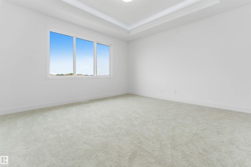 Spacious room featuring light-colored carpeting and a multi-pane window - 4234 63 Street, Beaumont, AB - Indoor Photo Showing Other Room