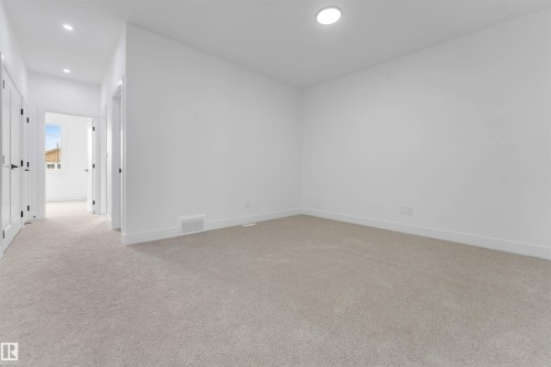 Carpeted room with a recessed ceiling light, white baseboards, and a neutral wall finish - 4234 63 Street, Beaumont, AB - Indoor Photo Showing Other Room