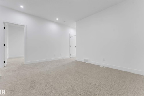 Spacious room featuring light-toned carpet, white walls, recessed ceiling lighting, and white baseboards - 4234 63 Street, Beaumont, AB - Indoor Photo Showing Other Room
