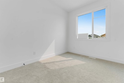 Bright interior space featuring a double-paned window, neutral carpeting, white baseboards, and a fresh white wall finish - 4234 63 Street, Beaumont, AB - Indoor Photo Showing Other Room