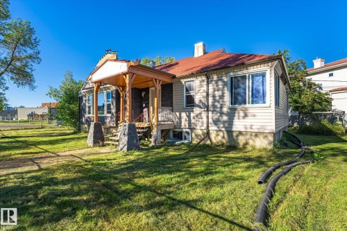 Siding exterior with a covered porch featuring wood columns and stone bases - 11008 109 Street Nw, Edmonton, AB 