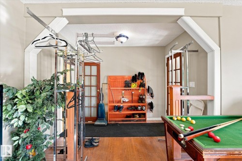 Hardwood flooring, arched doorways with decorative trim, and a ceiling-mounted light fixture - 11008 109 Street Nw, Edmonton, AB 