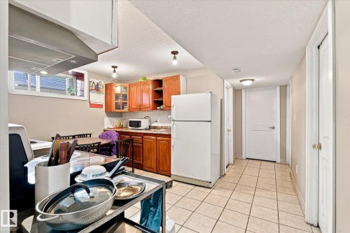 Kitchen area with light wood-finish cabinetry, a window, and tile flooring - 11008 109 Street Nw, Edmonton, AB 