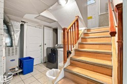 Hardwood stairs with wood railings, tile flooring, and white panel doors - 