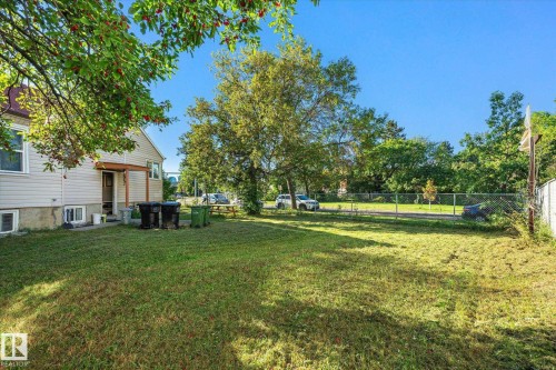 Expansive green space with mature trees and a chain-link fence - 11008 109 Street Nw, Edmonton, AB 