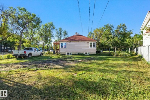 Spacious property featuring a single-story residence with a red-tiled roof and light-colored siding - 11008 109 Street Nw, Edmonton, AB 