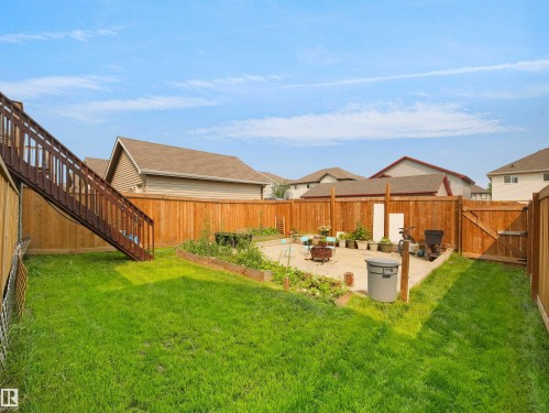 Expansive backyard featuring a concrete patio, raised garden beds, and a full wood fence - 1216 29 Avenue Nw, Edmonton, AB - Outdoor
