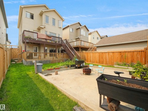 Expansive backyard featuring a large concrete patio, full privacy fencing, and a multi-level deck system with a lower patio and an upper balcony - 1216 29 Avenue Nw, Edmonton, AB - Outdoor With Deck Patio Veranda