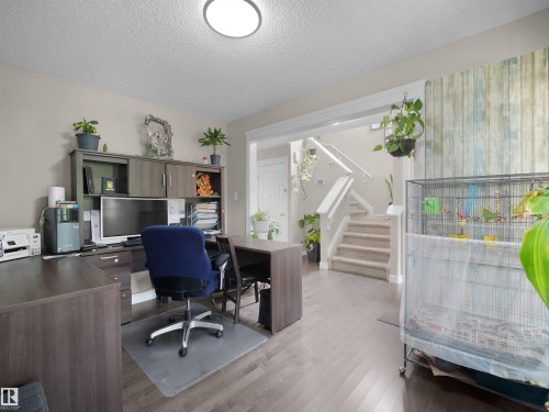 Open-concept room featuring wood-finish flooring, a neutral wall color, and a built-in office cabinetry system - 1216 29 Avenue Nw, Edmonton, AB - Indoor Photo Showing Office