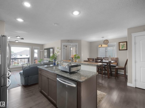 Kitchen island featuring a granite countertop and built-in dishwasher - 1216 29 Avenue Nw, Edmonton, AB - Indoor