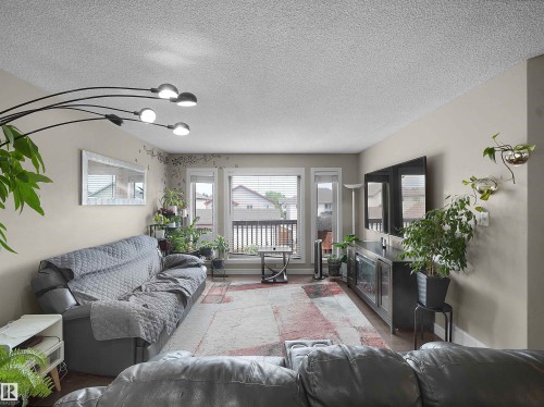 Spacious living area featuring light-toned walls, textured ceilings, and wood-finish flooring - 1216 29 Avenue Nw, Edmonton, AB - Indoor Photo Showing Living Room