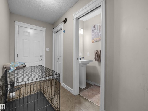 Interior hallway featuring a paneled door, a bi-fold closet door, and a dedicated powder room with a pedestal sink - 1216 29 Avenue Nw, Edmonton, AB - Indoor Photo Showing Other Room