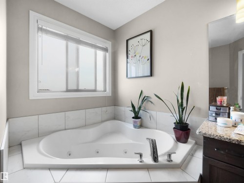 Corner soaking tub with integrated jets and chrome fixtures - 1216 29 Avenue Nw, Edmonton, AB - Indoor Photo Showing Bathroom
