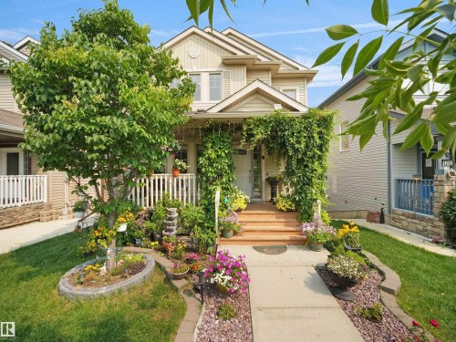 Two-story residence featuring a covered front porch with a wood-finish floor and white railings - 1216 29 Avenue Nw, Edmonton, AB - Outdoor With Deck Patio Veranda