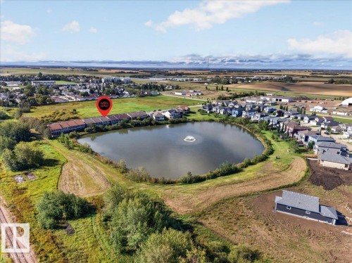 Townhome community situated along a tranquil pond featuring a central fountain - #7 10500 103 Av, Morinville, AB 
