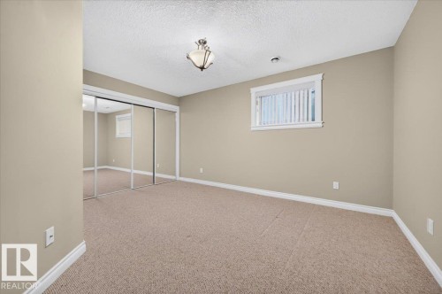 Carpeted flooring, neutral wall tones, recessed window, ceiling-mounted light fixture, mirrored sliding closet doors - #7 10500 103 Av, Morinville, AB 