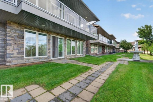 Stone veneer exterior with multiple balconies featuring glass railings - #7 10500 103 Av, Morinville, AB 