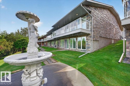 Stone-clad exterior with multiple balconies featuring glass railings - #7 10500 103 Av, Morinville, AB 