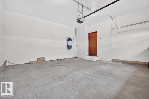 Concrete flooring, white walls, and a wood-panel door - #7 10500 103 Av, Morinville, AB 