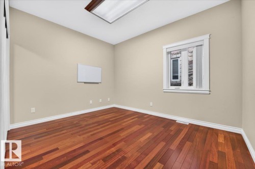 Hardwood flooring throughout, neutral wall paint, white trim, and a rectangular window - #7 10500 103 Av, Morinville, AB 