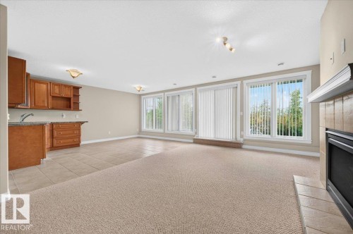 Built-in wet bar with wood cabinetry and stone-finish countertop - #7 10500 103 Av, Morinville, AB 