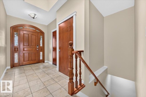 Arched wooden entry door with leaded glass sidelights and transom - #7 10500 103 Av, Morinville, AB 