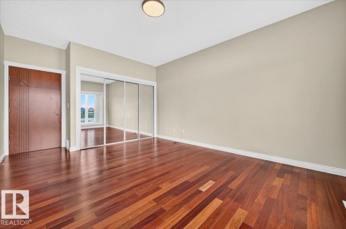 Rich wood-finish flooring complements the neutral wall tones - #7 10500 103 Av, Morinville, AB 