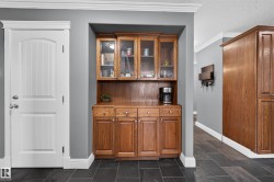 Built-in cabinetry with glass-front upper cabinets, durable tile flooring, and crisp white crown molding - 