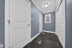 Slate tile flooring, white trim, white paneled doors, white bi-fold closet doors, and recessed lighting - 