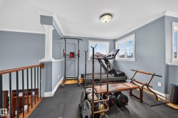 Upper-level space featuring crown molding, white trim, and multiple windows - 