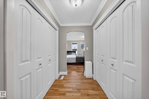 Hardwood-finish flooring leading to an arched doorway - 6904 18 Avenue Sw, Edmonton, AB 