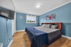 Hardwood-finish flooring, white trim, and a window with white casing - 