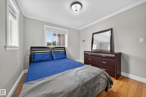 Hardwood flooring, painted walls, crown molding, and two windows - 6904 18 Avenue Sw, Edmonton, AB 