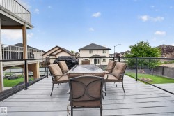 Upper-level deck with glass panel railing and painted wood-finish surface - 