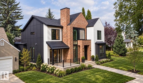 Contemporary residence featuring a striking brick and panel facade, a covered entry with black railing, and a gabled roofline - 10414 134 Street Nw, Edmonton, AB 