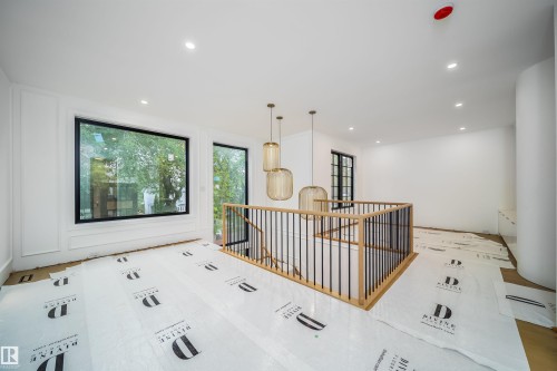 Modern staircase featuring wood railings and black spindles - 10414 134 Street Nw, Edmonton, AB 