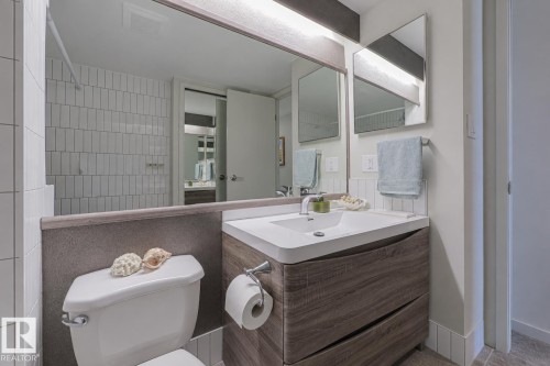 Modern bathroom featuring a floating vanity with rectangular sink, white quartz countertop, and polished chrome fixtures - #2005 10149 Saskatchewan Dr Nw, Edmonton, AB 