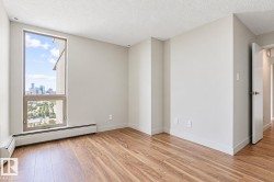 Wood-finish flooring, white trim, and a high ceiling - 