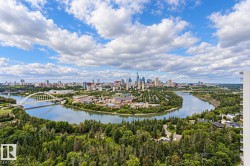 Expansive urban landscape with a river, bridge, and distant city skyline - 