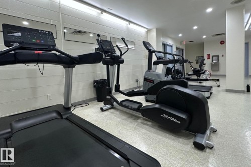 Fitness center featuring multiple exercise machines, mirrored walls, and recessed lighting - #2005 10149 Saskatchewan Dr Nw, Edmonton, AB 