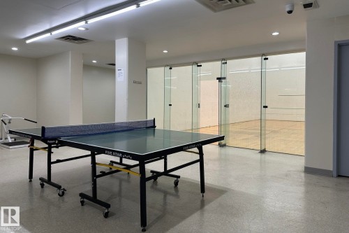 Recreation area featuring a table tennis setup, glass-enclosed court, and polished concrete flooring - #2005 10149 Saskatchewan Dr Nw, Edmonton, AB 