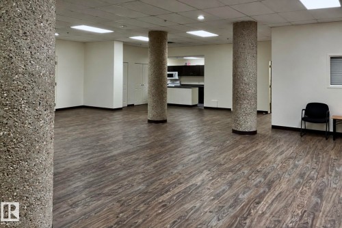 Open concept room with wood-finish flooring, exposed aggregate columns, recessed lighting, and a white ceiling - #2005 10149 Saskatchewan Dr Nw, Edmonton, AB 