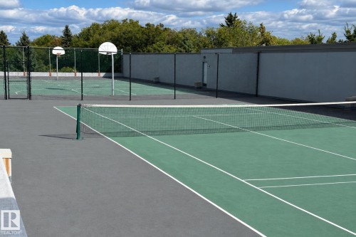 Tennis court with a net, marked lines, and adjacent basketball courts with hoops - #2005 10149 Saskatchewan Dr Nw, Edmonton, AB 